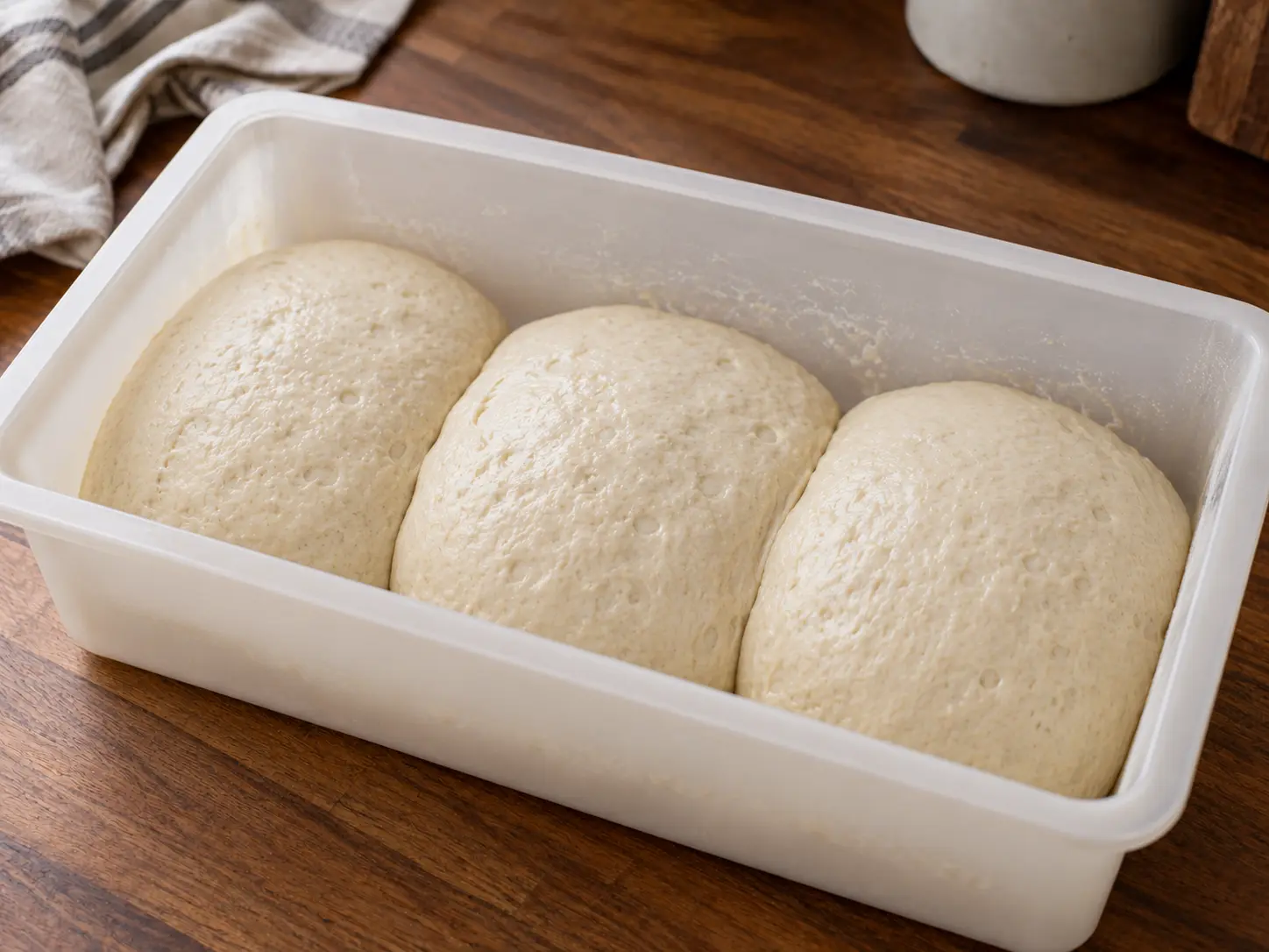Pizzadeegbollen die afgedekt rusten en rijzen