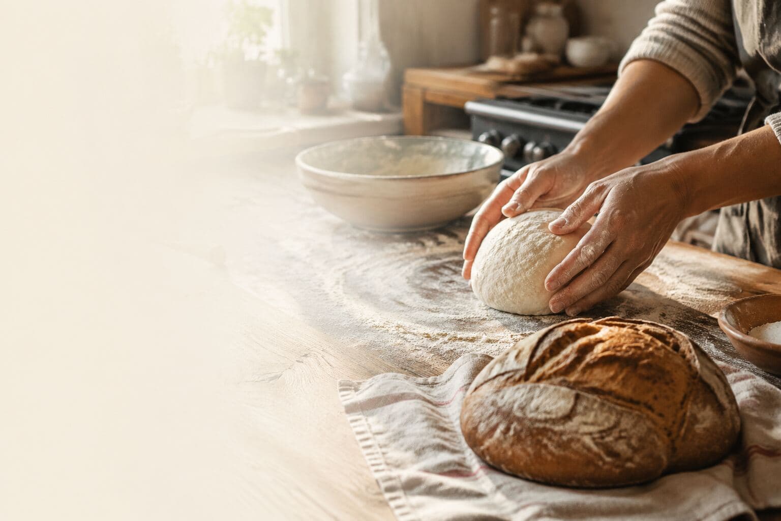 A home baker shapes dough on a flour-dusted worktop.